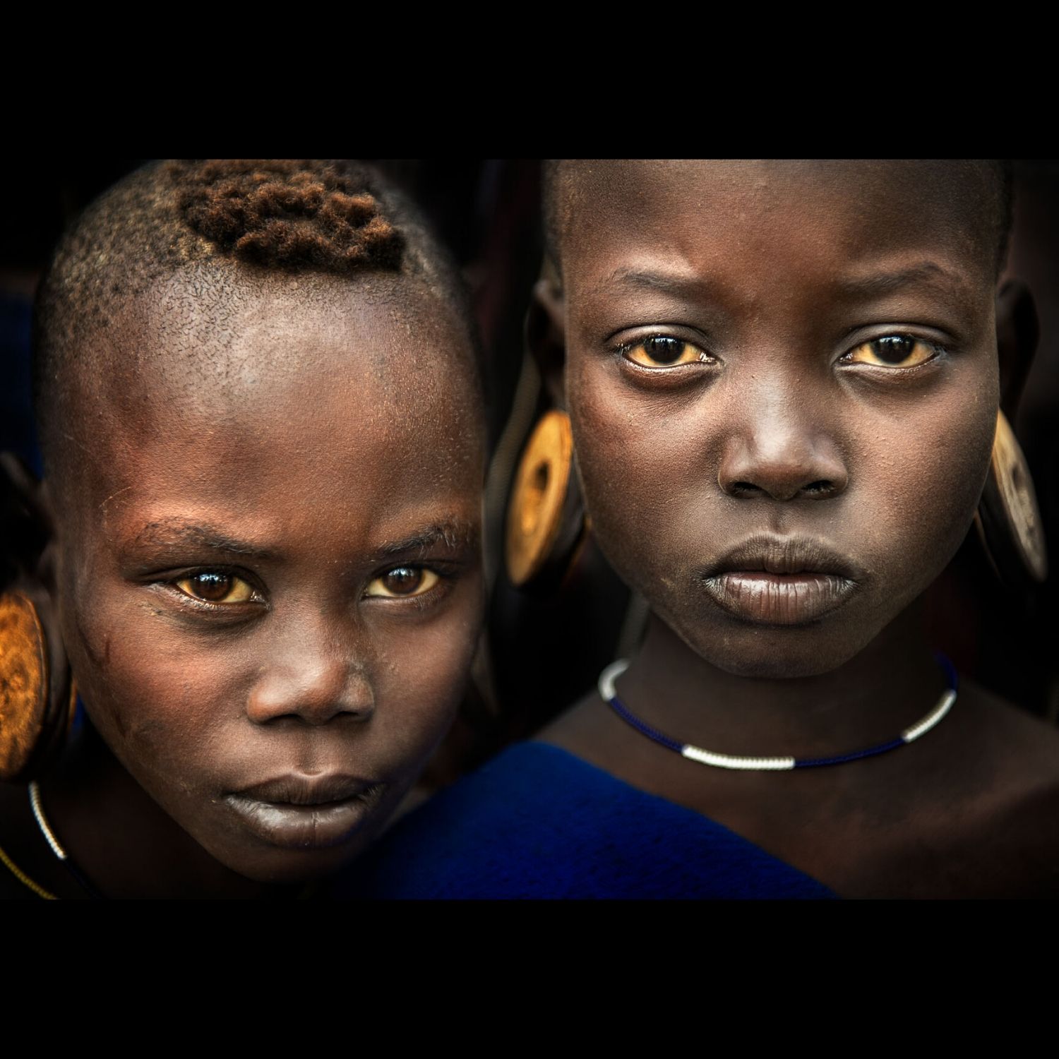 Purchase Portrait Photograph of children from the Mursis tribe of Ethiopia photographed by professional travel photographer Ignacio Palacios